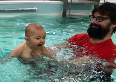 Baby having a great time swimming with Daddy