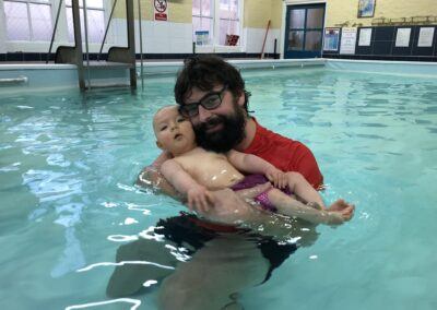 Baby relaxing on back in the water with daddy