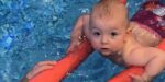 baby swimming with pool noodle