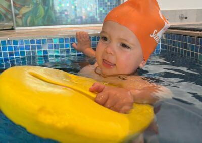 Baby 2 - Superman with board, UNAIDED pushing off pool wall confidently