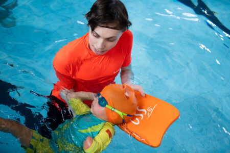 toddler swimming back float with instructor